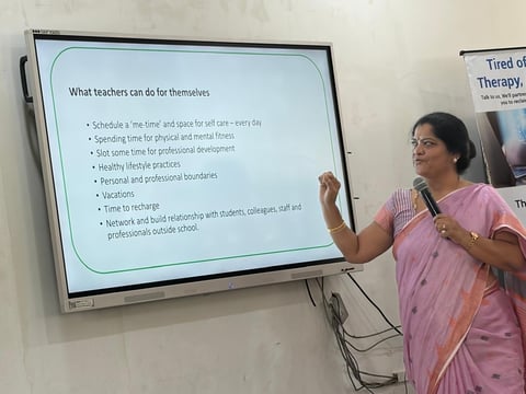 Teacher presenting on interactive whiteboard displaying a list of self-care strategies for educators